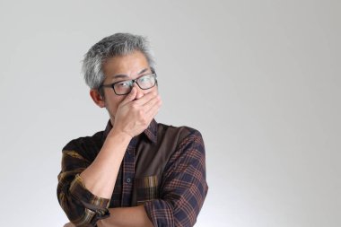 Beyaz arka planda duran kıdemli Asyalı adam.