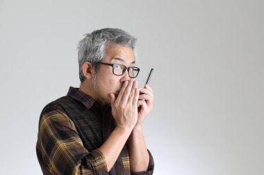 Beyaz arka planda duran kıdemli Asyalı adam.