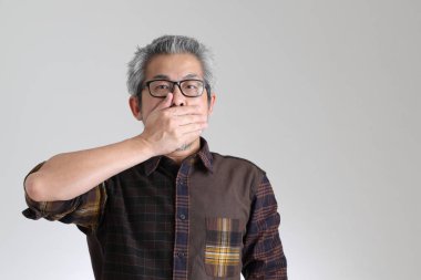 Beyaz arka planda duran kıdemli Asyalı adam.