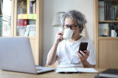 Ev stüdyosunda çalışan Asyalı adam..