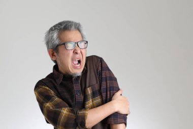 Beyaz arka planda duran kıdemli Asyalı adam.