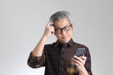 Beyaz arka planda duran kıdemli Asyalı adam.