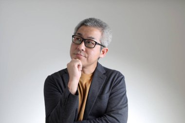 Beyaz arka planda duran akıllı Asyalı adam..