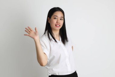 Üniversite üniformalı Asyalı kız beyaz arka planda duruyor..