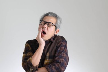 Beyaz arka planda duran kıdemli Asyalı adam.