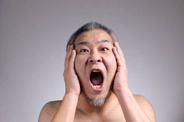 Gri arka planda Asyalı bir adamın portresi..