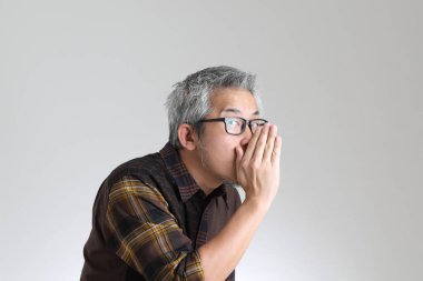 Beyaz arka planda duran kıdemli Asyalı adam.