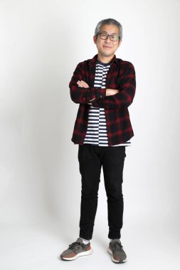 Beyaz arka planda duran Asyalı adam.