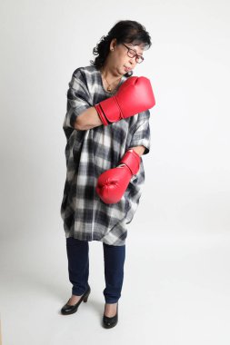 Beyaz arka planda duran yaşlı Asyalı kadın..