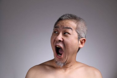 Gri arka planda Asyalı bir adamın portresi..