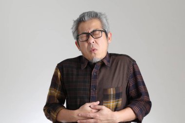 Beyaz arka planda duran kıdemli Asyalı adam.