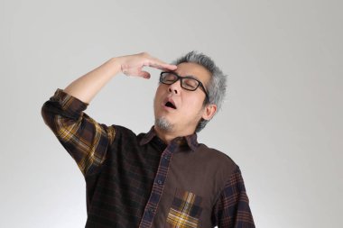 Beyaz arka planda duran kıdemli Asyalı adam.