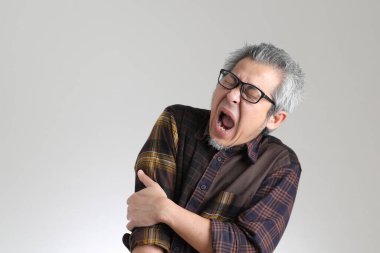 Beyaz arka planda duran kıdemli Asyalı adam.