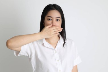 Üniversite üniformalı Asyalı kız beyaz arka planda duruyor..