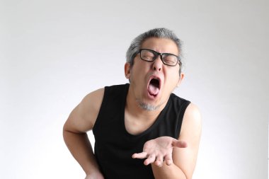 Beyaz arka planda duran spor üniformalı yaşlı Asyalı adam..