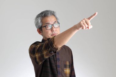 Beyaz arka planda duran kıdemli Asyalı adam.