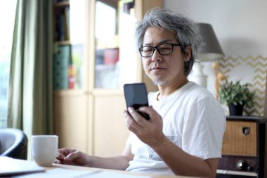 Ev stüdyosunda çalışan Asyalı adam..