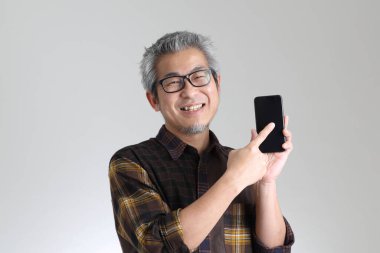 Beyaz arka planda duran kıdemli Asyalı adam.