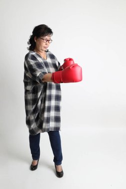 Beyaz arka planda duran yaşlı Asyalı kadın..