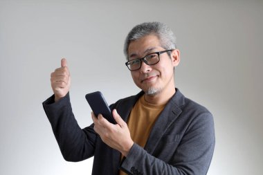 Beyaz arka planda duran akıllı Asyalı adam..