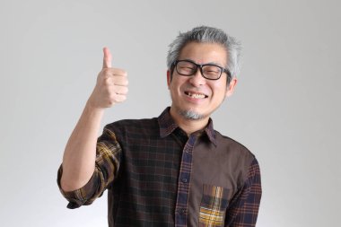 Beyaz arka planda duran kıdemli Asyalı adam.