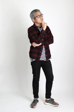 Beyaz arka planda duran Asyalı adam.