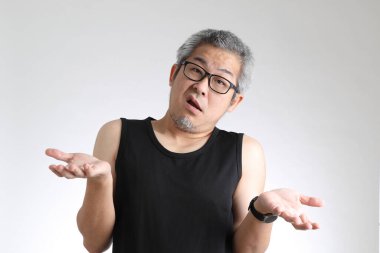 Beyaz arka planda duran spor üniformalı yaşlı Asyalı adam..