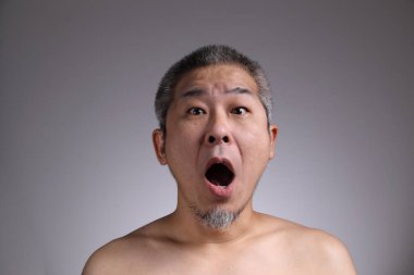 Gri arka planda Asyalı bir adamın portresi..