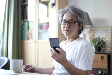 Ev stüdyosunda çalışan Asyalı adam..