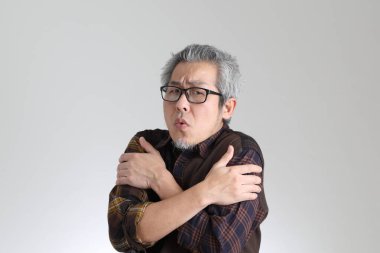 Beyaz arka planda duran kıdemli Asyalı adam.