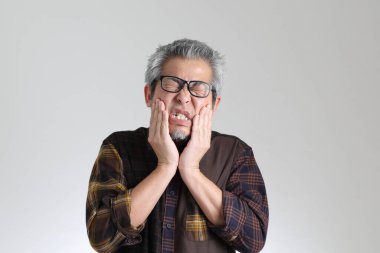 Beyaz arka planda duran kıdemli Asyalı adam.