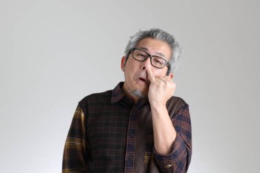 Beyaz arka planda duran kıdemli Asyalı adam.