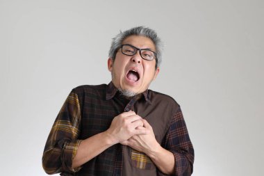 Beyaz arka planda duran kıdemli Asyalı adam.