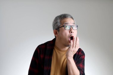 Beyaz arka planda duran Asyalı adam..