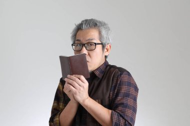 Beyaz arka planda duran kıdemli Asyalı adam.