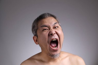 Gri arka planda Asyalı bir adamın portresi..