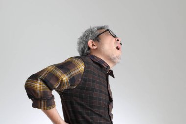 Beyaz arka planda duran kıdemli Asyalı adam.