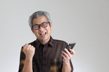 Beyaz arka planda duran kıdemli Asyalı adam.