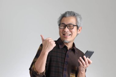 Beyaz arka planda duran kıdemli Asyalı adam.