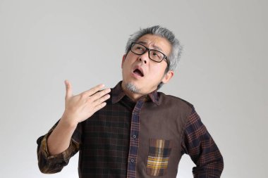 Beyaz arka planda duran kıdemli Asyalı adam.