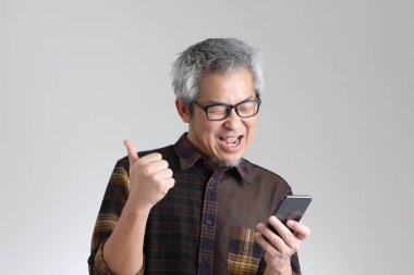 Beyaz arka planda duran kıdemli Asyalı adam.