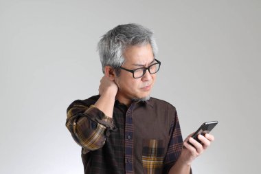 Beyaz arka planda duran kıdemli Asyalı adam.