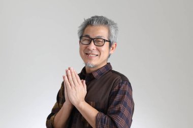 Beyaz arka planda duran kıdemli Asyalı adam.