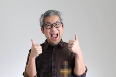 Beyaz arka planda duran kıdemli Asyalı adam.