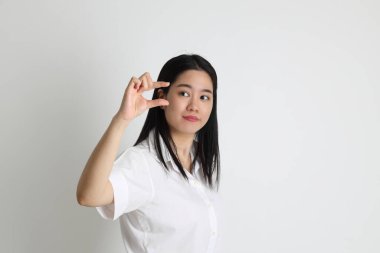 Üniversite üniformalı Asyalı kız beyaz arka planda duruyor..