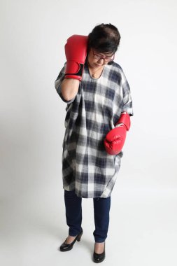 Beyaz arka planda duran yaşlı Asyalı kadın..