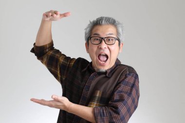 Beyaz arka planda duran kıdemli Asyalı adam.