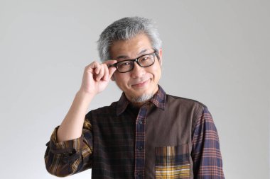 Beyaz arka planda duran kıdemli Asyalı adam.