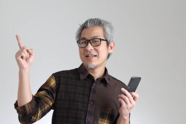 Beyaz arka planda duran kıdemli Asyalı adam.