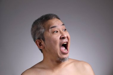 Gri arka planda Asyalı bir adamın portresi..